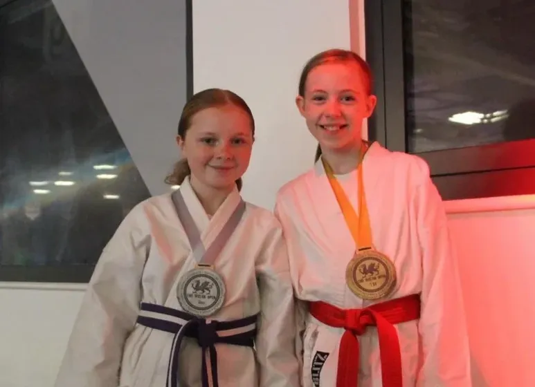 Two junior members of Maesteg Shotokan Karate Club in karate gi with medals won at a competition